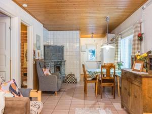 a kitchen and living room with a table and a fireplace at Holiday Home Mäkimökki by Interhome in Palikainen