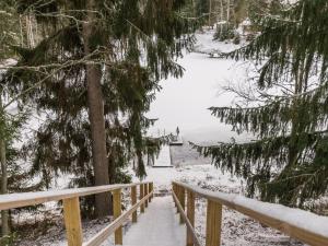 un escalier en bois menant à un lac dans la neige dans l'établissement Holiday Home Mäkimökki by Interhome, à Palikainen