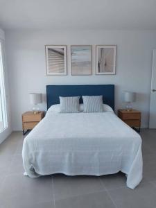 - une chambre avec un grand lit blanc et 2 tables dans l'établissement Gran Canet luxury apartment with sea view, à Canet d'En Berenguer