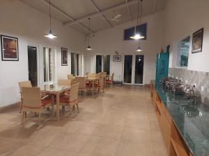 a dining room with tables and chairs and lights at Azalea in Jajal