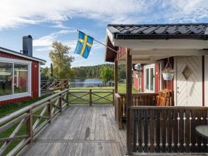 una casa con una bandiera su un ponte di legno di Chalet Toltorp - SDM100 by Interhome a Katrineholm