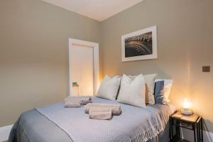 1 dormitorio con 1 cama con toallas en Stunning Boutique Flat in Central Location - Beatrice en Bath