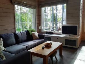 ein Wohnzimmer mit einem Sofa und einem TV in der Unterkunft Holiday Home Villa raita by Interhome in Oravisalo