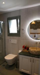 a bathroom with a toilet and a sink and a mirror at Unity Villa in Pilaroú