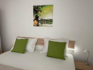 a bedroom with a bed with green and white pillows at Relaxing Bucharest Airport Residences & Therme-SELF CHECK-IN in Otopeni