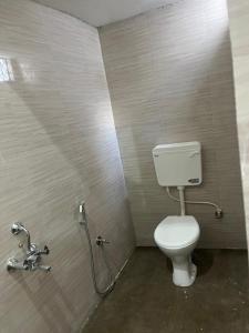 a bathroom with a white toilet in a stall at Indiana home stay in Khajurāho