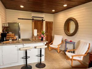 a kitchen with a counter and chairs and a mirror at La Vida Belize - Studio in Riversdale