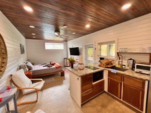 a room with a kitchen and a living room with a couch at La Vida Belize - Studio in Riversdale