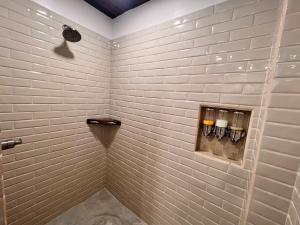 a white tiled shower with three candles in a bathroom at La Vida Belize - Studio in Riversdale