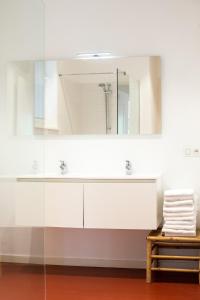 ein weißes Badezimmer mit einem Waschbecken und einem Spiegel in der Unterkunft The Industria - Stylish in Historical Center in Antwerpen