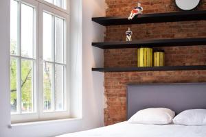 a bedroom with a brick wall with a bed and a window at The Industria - Stylish in Historical Center in Antwerp