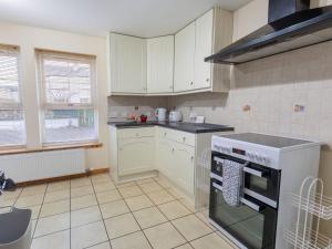 a kitchen with white cabinets and a stove top oven at Holiday Home Lodge Road-1 by Interhome in Inverness