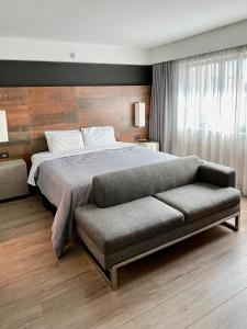 サンパウロにあるFlat particular incrível dentro do hotel M Ibirapuera em Moemaのベッドルーム(大型ベッド1台、ソファ付)