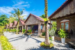 a house with palm trees in front of it at Mai Phuong Resort Phu Quoc in Phú Quốc