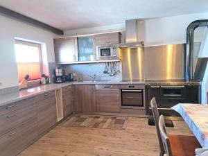 a kitchen with wooden cabinets and stainless steel appliances at Holiday Home Pfundshof by Interhome in Hippach