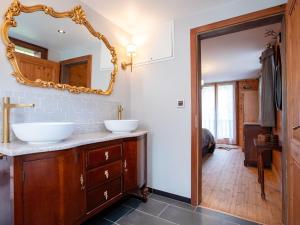 a bathroom with two sinks and a mirror at Chalet Chalet Tetras by Interhome in Chesières
