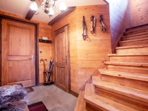Zimmer mit Holzwänden und -treppen und einer Tür in der Unterkunft Chalet Chalet Tetras by Interhome in Chesières