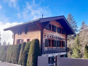 a wooden house with a fence in front of it at Chalet Chalet Tetras by Interhome in Chesières