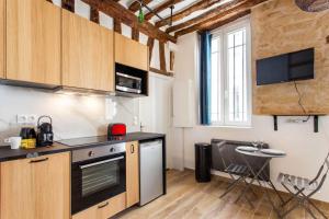 a kitchen with a stove and a sink in a room at Superb apartment- 4P- Montorgueil Nazareth in Paris