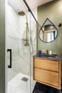 a bathroom with a shower with a sink and a mirror at Superb apartment- 4P- Montorgueil Nazareth in Paris