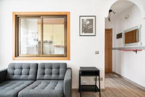 - un salon avec un canapé et une fenêtre dans l'établissement Geranios 32 (Plaza Castilla), à Madrid