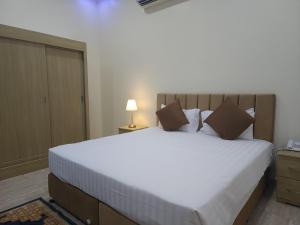 a bedroom with a large white bed in a room at Sohar Hotel - فندق صحار in Sohar