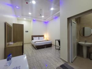 a bedroom with a bed and a sink and a bathroom at Sohar Hotel - فندق صحار in Sohar