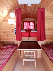 una habitación con 2 camas y una mesa en una casa pequeña en Camping Officiel Wollefsschlucht Echternach, en Echternach