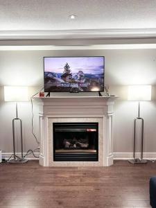 sala de estar con chimenea y TV de pantalla plana. en Room in Oshawa, 24/7 Security, Free Parking, en Oshawa