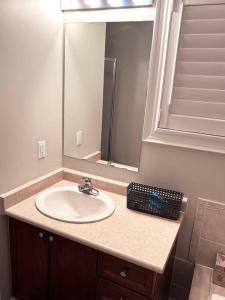 a bathroom counter with a sink and a mirror at Room in Oshawa, 24/7 Security, Free Parking in Oshawa