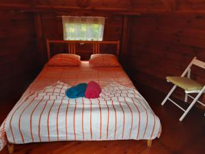 een bed met twee hoeden en een stoel in een kamer bij Camping Officiel Wollefsschlucht Echternach in Echternach