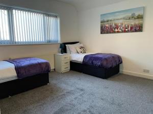 a bedroom with two beds and a painting on the wall at Elm, Large 5 Bedrooms, Sleeps 10 With Parking in Birmingham