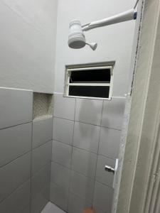 a bathroom with a shower with a window at Quarto Central in Guararema