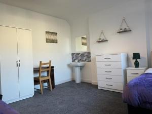 a bedroom with a bed and a desk and a chair at Elm, Large 5 Bedrooms, Sleeps 10 With Parking in Birmingham