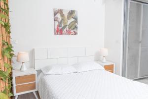 a white bedroom with a bed and two lamps at Apartamento Loft Edificio Soho 906 in Armenia