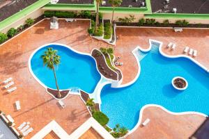 uitzicht op een groot zwembad met een resort bij Sky Smart Home Hi-End Services Media Streaming in Adeje