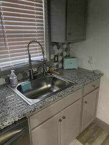 a kitchen counter with a sink and a window at Comfy College Cottage Near Stadium & Campus in Tallahassee