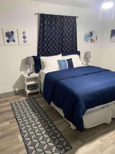 a bedroom with a blue bed with a blue headboard at Comfy College Cottage Near Stadium & Campus in Tallahassee