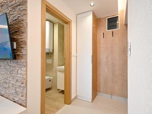 pasillo con baño con aseo y TV en Grand Apartman Jahorina, en Jahorina 57 fotos más