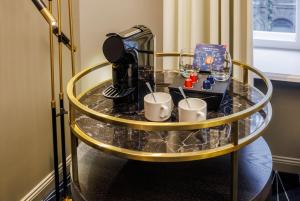 Una mesa de cristal con una cafetera y tazas encima. en Movenpick Hotel Tallinn, en Tallin