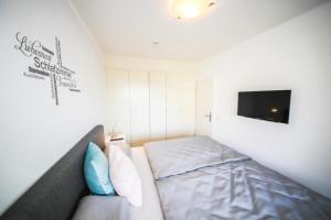 ニーンドルフにあるFerienwohnung Koje 117 im Haus Carpe Diemのベッド1台とテレビが備わる小さな客室です。