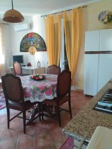 una cocina con mesa, sillas y mesa y una habitación en La Villetta, en Olmedo