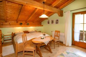 1 dormitorio con 1 cama, mesa y sillas en Ferienwohnung Hinterreiter en Ruhpolding