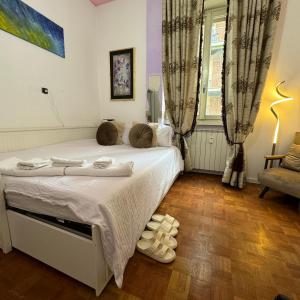 een slaapkamer met een bed met witte lakens en een raam bij Fenice in Bergamo