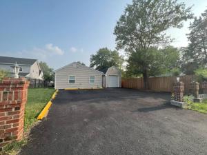 a parking lot with a house and a fence at The Castilian by Keywee Rentals in Manassas