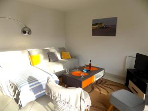 uma sala de estar com um sofá e uma mesa em Royan Quartier du Parc - APPARTEMENT proche PLAGE et COMMERCES - WIFI em Royan