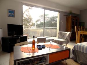uma sala de estar com uma mesa com copos de vinho em Royan Quartier du Parc - APPARTEMENT proche PLAGE et COMMERCES - WIFI em Royan