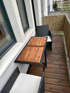 y balcón con mesa y sillas de madera. en Ferienwohnung Lorenz mit kostenlosem Parkplatz Netflix Boxspringbett Küche, en Magdeburgo