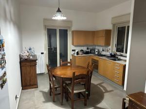 a kitchen with a wooden table and chairs at Etna sotto il ciliegio in Ragalna