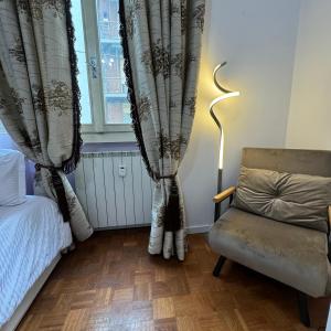 een slaapkamer met een bed, een stoel en een raam bij Fenice in Bergamo